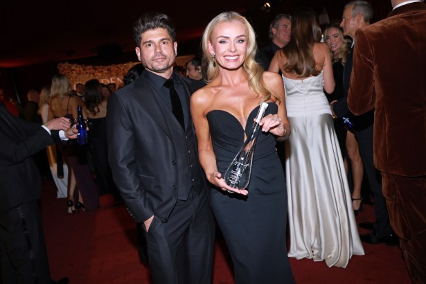 Katherine Jenkins and Andrew Levitas posing together on the Golden Globes red carpet, with Katherine holding a distinctive hand‑blown Cygnet gin bottle.