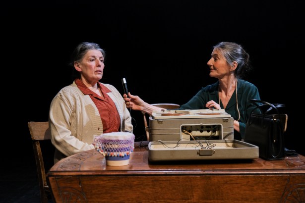 Lady Amy Parry‑Williams sits beside a recording device talking with a woman living in a Denbighshire workhouse while recording traditional Welsh folk songs.