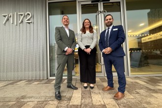 Cllr Rob Stewart standing with Briony Cotter and James Pearson at the 71/72 Kingsway office development in Swansea.