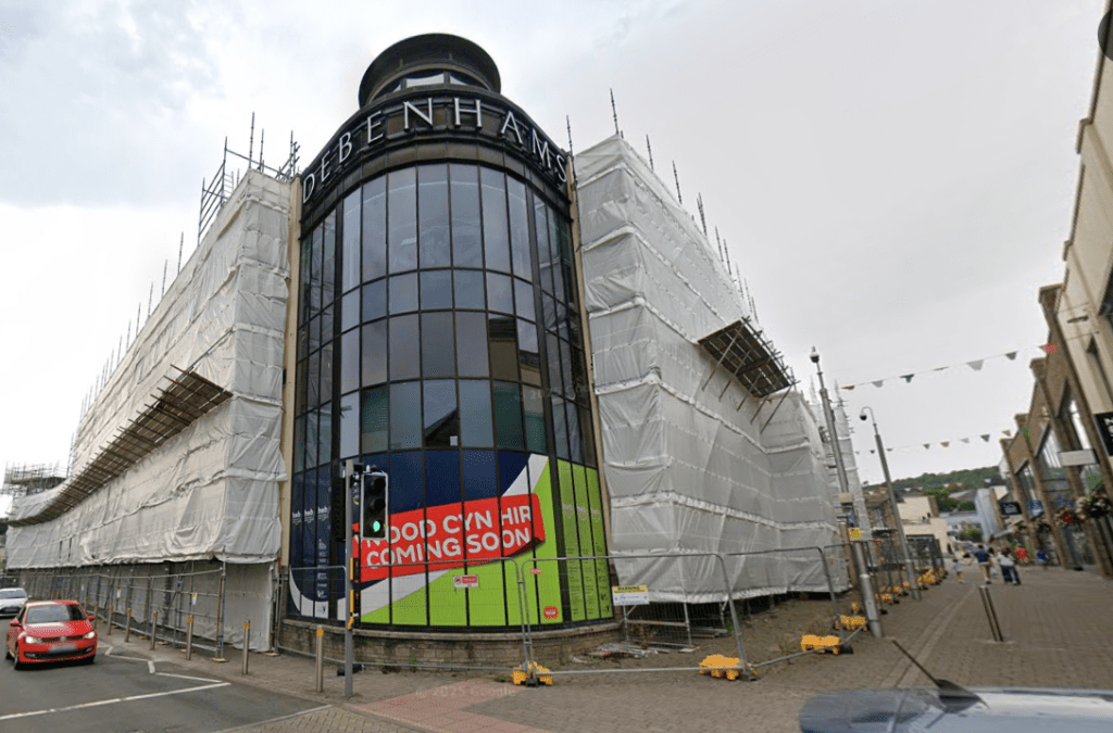 Street‑level view of the former Debenhams building in St Catherine’s Walk, Carmarthen, showing the large multi‑storey frontage.
