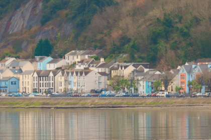 Scenic view of Mumbles from across the water, showing colourful buildings along the seafront.