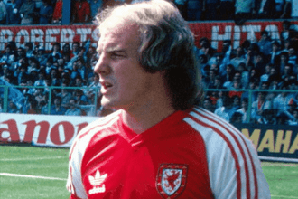 Terry Yorath standing pitchside in FAW training gear during his time with the Wales national team.