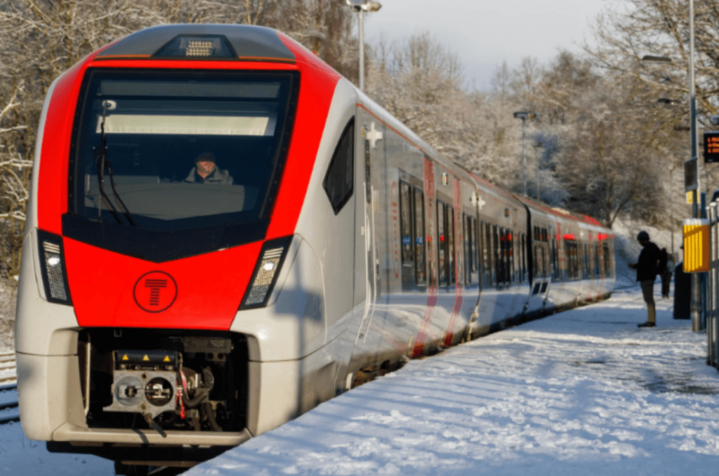 Front view of a TfW train surrounded by falling snow during Storm Goretti.
