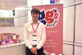 Toby Link‑Jones standing with a display of GG’s Gelato products and branded signage.