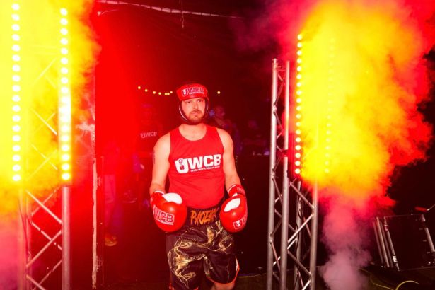 Anthony Trubridge walking into the boxing arena through a gateway of fire during his Ultra White Collar Boxing entrance.