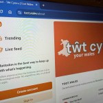 Alt text: Laptop screen showing the Tŵt social platform interface, highlighting the community‑owned Welsh network featured in the “Pethau Bychain” campaign.