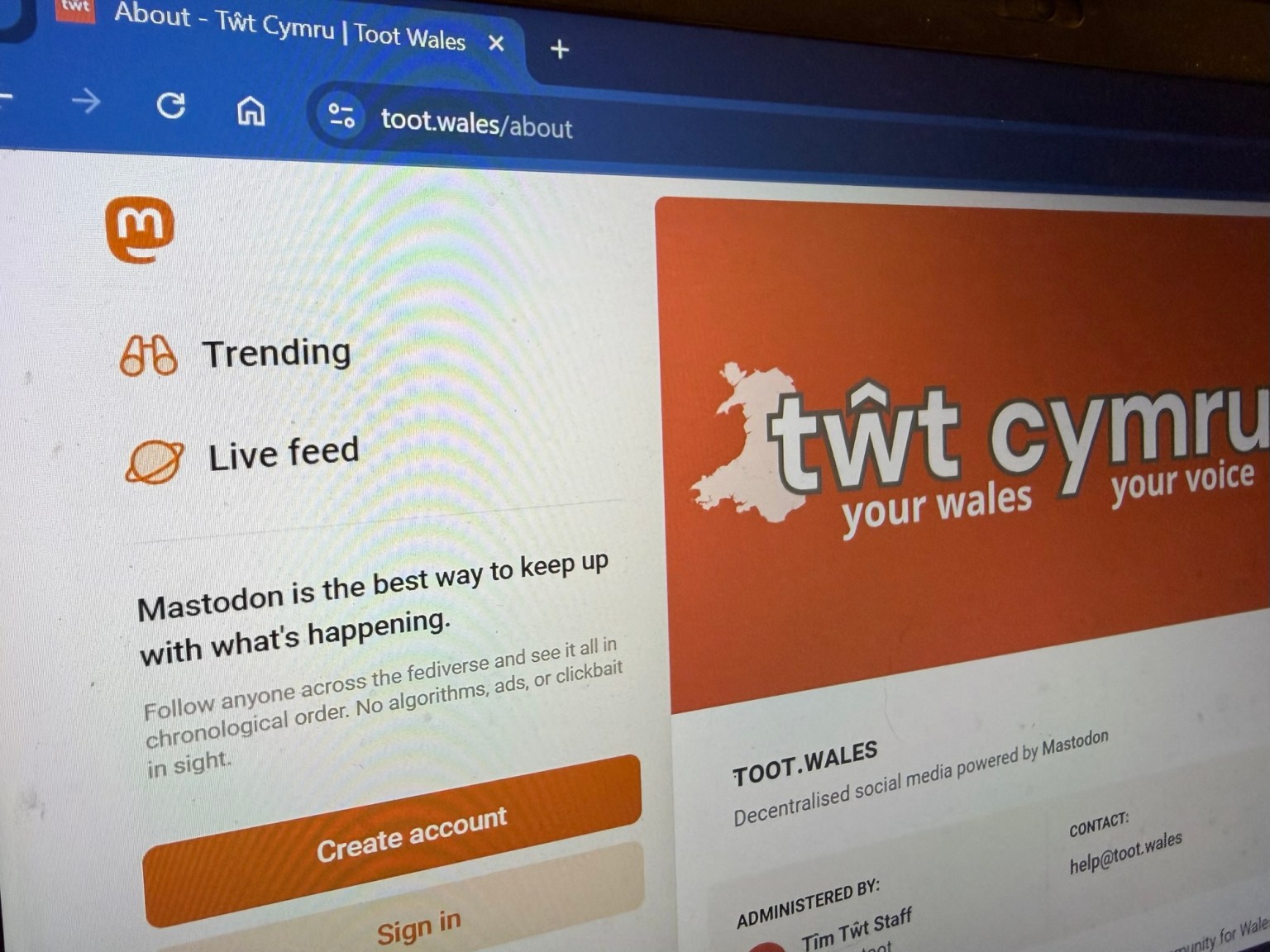 Alt text: Laptop screen showing the Tŵt social platform interface, highlighting the community‑owned Welsh network featured in the “Pethau Bychain” campaign.