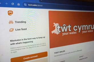 Alt text: Laptop screen showing the Tŵt social platform interface, highlighting the community‑owned Welsh network featured in the “Pethau Bychain” campaign.