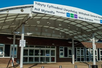 Main entrance of Withybush General Hospital in Haverfordwest, showing the bilingual signage and canopy structure above the doors.