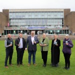 Group photo taken outside Swansea University’s main campus entrance, showing staff and quoted partners at the launch of the 2GoCup reusable cup initiative.