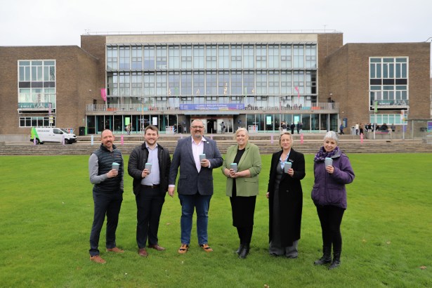 Group photo taken outside Swansea University’s main campus entrance, showing staff and quoted partners at the launch of the 2GoCup reusable cup initiative.