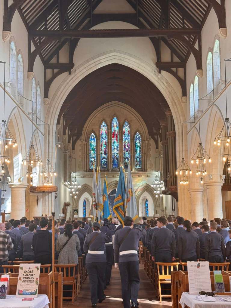 RAF Air Cadets carrying ceremonial flags down the central aisle of Swansea Minster during the anniversary service.