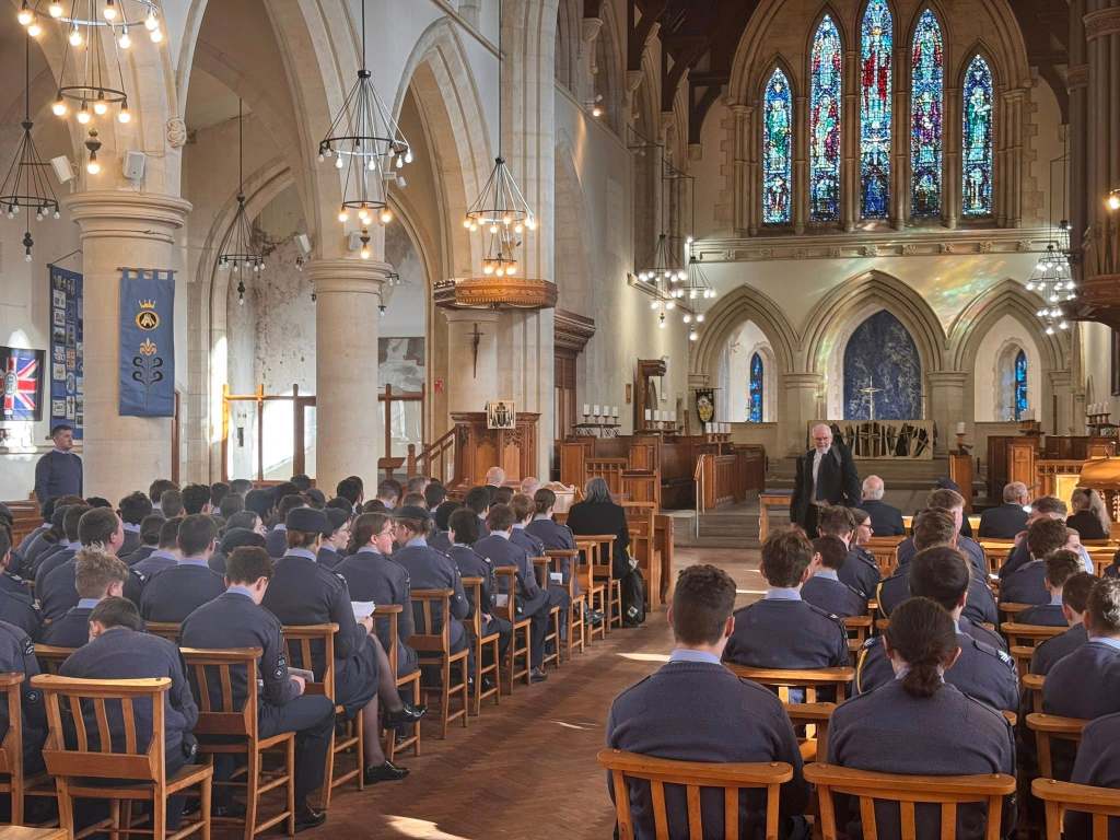 RAF Air Cadets holding flags at the front of Swansea Minster as clergy stand behind the altar during the anniversary service.