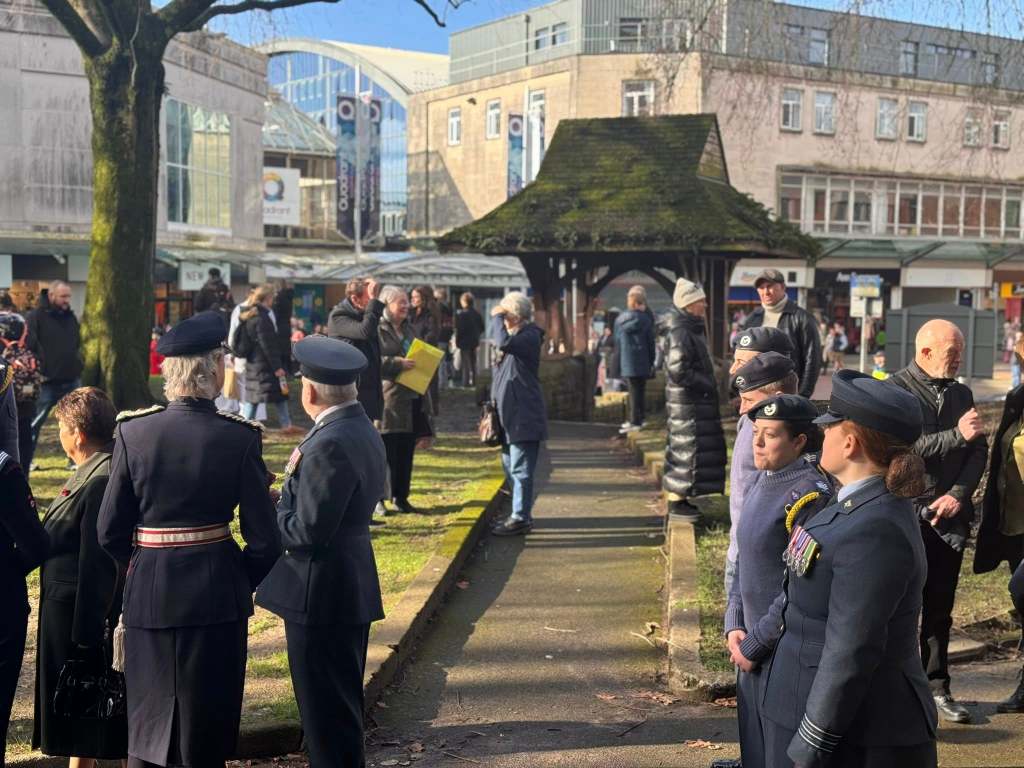 Members of the public and uniformed personnel gathered in an outdoor civic space during the RAF Air Cadets anniversary event.
