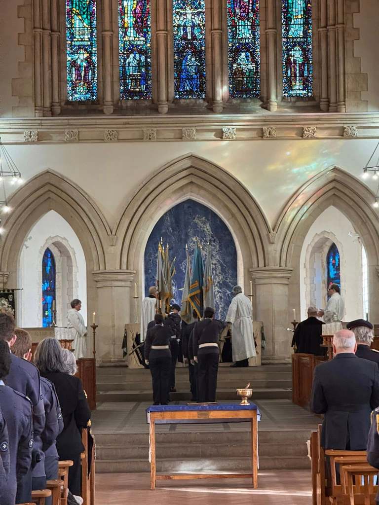 A young RAF Air Cadet stands at a lectern delivering a reading during the anniversary service at Swansea Minster.