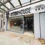 Front view of The Tinhouse taproom in Llanelli, showing the craft beer and pizzeria signage above the entrance and the interior visible through the glass frontage.