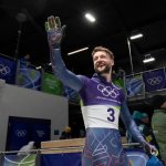 Marcus Wyatt waving in his Team GB kit at the Milano Cortina 2026 Winter Olympics.