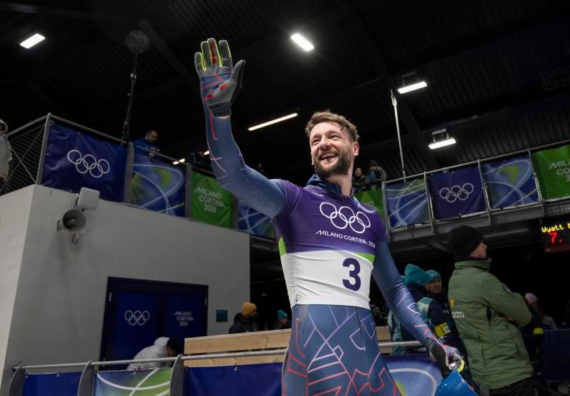 Marcus Wyatt waving in his Team GB kit at the Milano Cortina 2026 Winter Olympics.