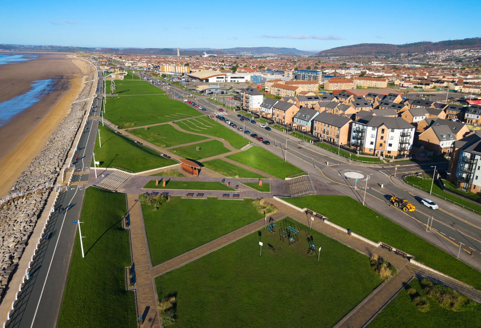 Aerial photograph of Aberavon seafront showing the promenade, beach, green spaces and nearby housing.