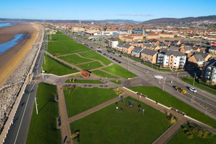 Aerial photograph of Aberavon seafront showing the promenade, beach, green spaces and nearby housing.