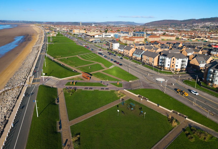 Aerial photograph of Aberavon seafront showing the promenade, beach, green spaces and nearby housing.