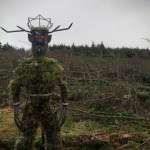 Close-up of the Green Man of Kilvey sculpture, a wire and moss figure with a crown and red eyes, on Kilvey Hill.