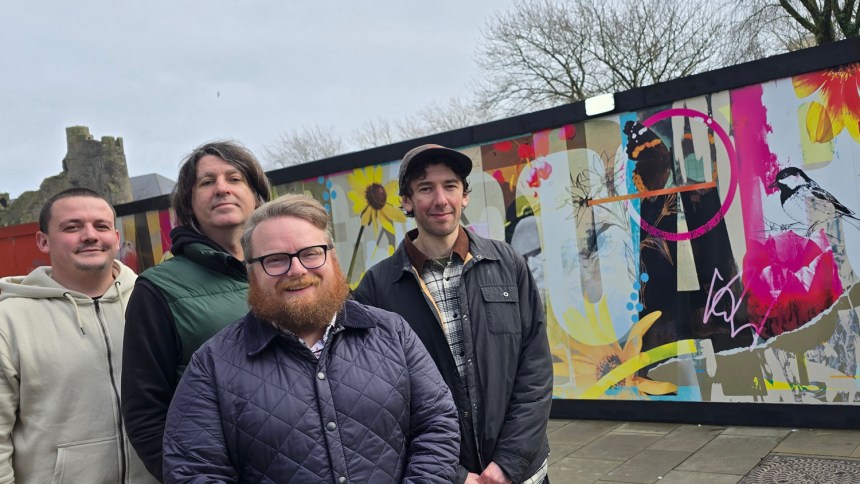 Group photo of Elliott King, artist Hasan Kamil and Oner Signs staff standing in front of the Castle Square Gardens artwork.