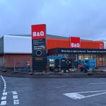 Exterior of the new B&Q Carmarthen store with construction fencing and equipment in front of the entrance.