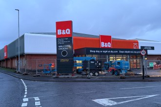 Exterior of the new B&Q Carmarthen store with construction fencing and equipment in front of the entrance.