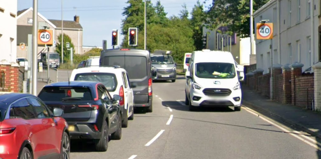 Image of the A4138 Halfway junction in Llanelli showing vehicles stopped at red lights and dual speed limit signs.