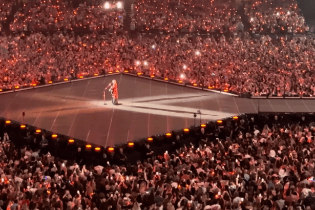 Taylor Swift performing on a central stage at the Principality Stadium in Cardiff during the 2024 Eras Tour.