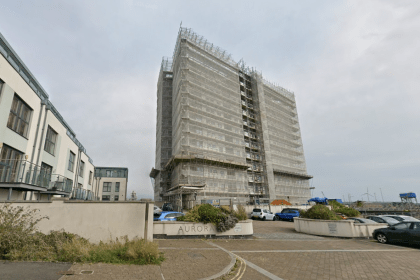 Aurora apartment building in Swansea Marina covered in scaffolding during remediation work