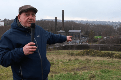 Cllr Joe Hale pointing at Kilvey Hill during video announcement