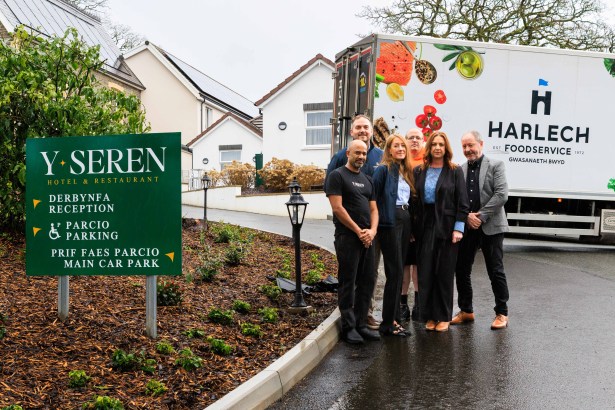 Outdoor group photo outside Y Seren Hotel showing head chef Navi Mudaly, Harlech Foodservice staff and hotel owners Andrea and Tudur Williams beside a branded delivery vehicle.