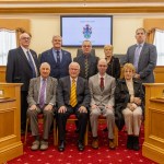 Independent councillors in the Llanelli Town Council chamber, seated and standing for a formal group photo. Leader Sean Rees is seated front row wearing a light grey suit and red tie.
