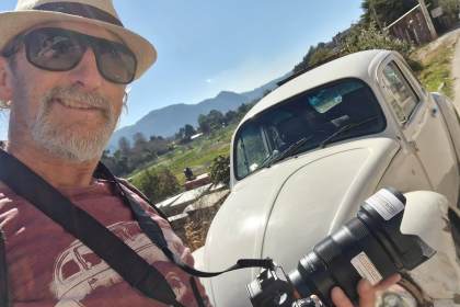 Paul O’Connor taking a photo in front of a vintage VW Beetle in the Mexican countryside.