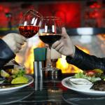 person holding clear wine glass with red wine
