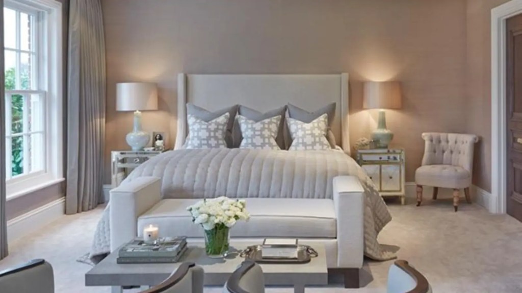 Stylish bedroom at Y Seren boutique hotel featuring a large upholstered bed, soft furnishings, mirrored bedside tables and natural light from tall windows.