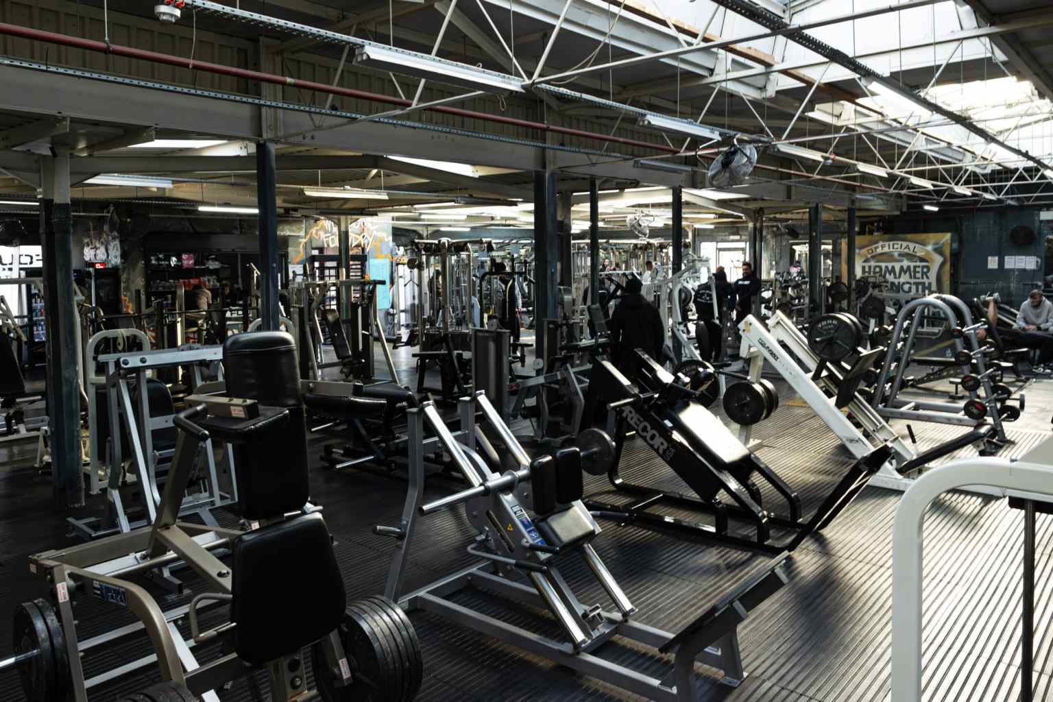 Interior of a Foundry Gym with weight machines, free weights and members training.
