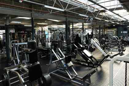 Interior of a Foundry Gym with weight machines, free weights and members training.