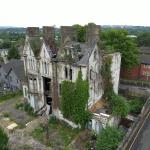 Aerial view of Danbert House in Morriston, Swansea, showing the dilapidated Victorian building with a damaged roof, broken windows and overgrown vegetation surrounding the structure.