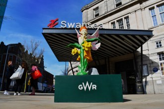 A colourful faery statue displayed outside Swansea railway station, inspired by Welsh folklore from Pennard Castle in the Gower.