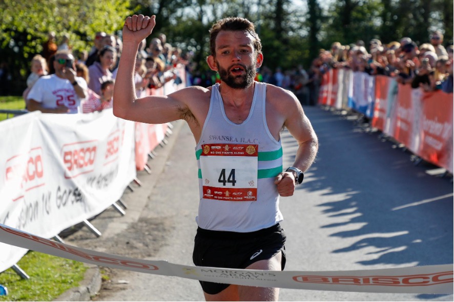 A runner breaks the tape at the finish line as the Gorseinon 10K delivers another dramatic finale.