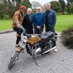 Fuzz Townshend, Sir Alan Bates, Ian and Tim Shaw pose with restored Triumph Bonneville after emotional rebuild reveal