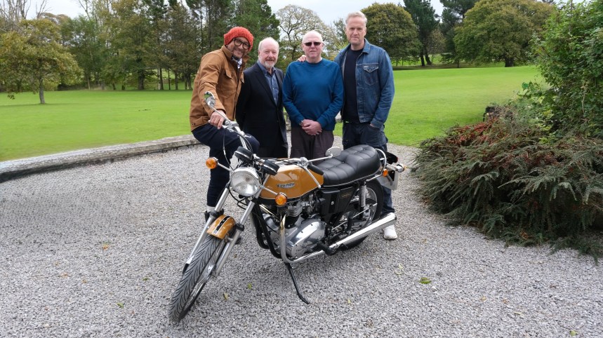Fuzz Townshend, Sir Alan Bates, Ian and Tim Shaw pose with restored Triumph Bonneville after emotional rebuild reveal