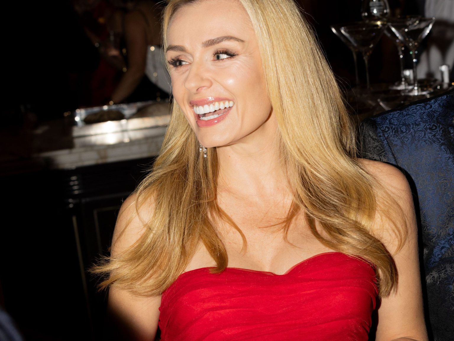 A close-up shot of Katherine Jenkins smiling, wearing a red dress.