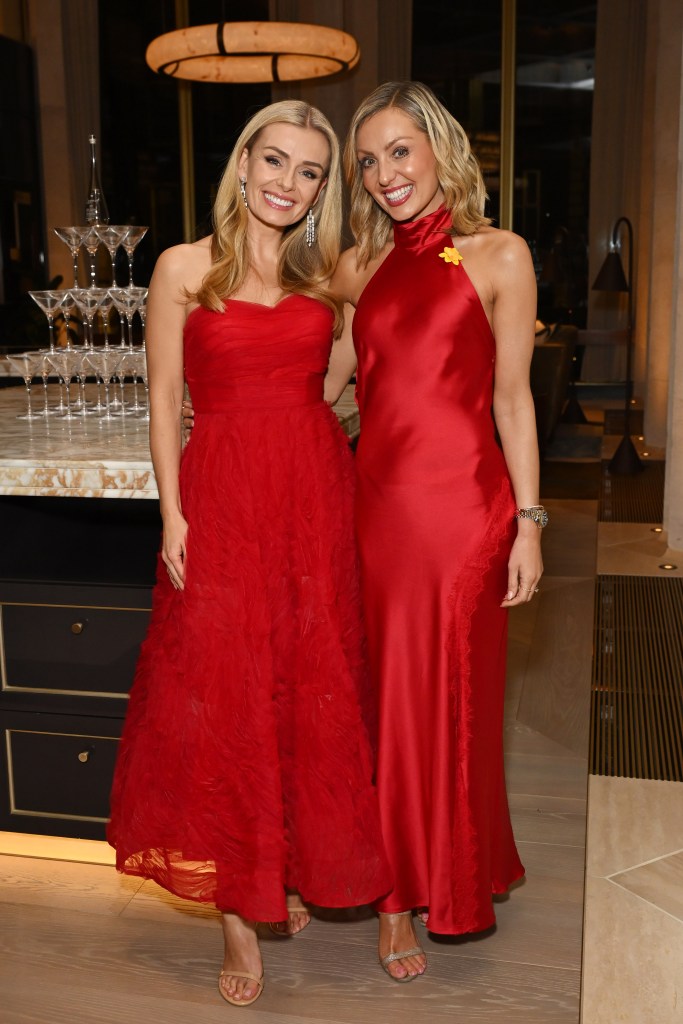 Katherine Jenkins and dancer Amy Dowden, both in red dresses, pose together at an event.