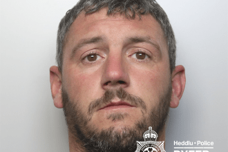A police custody photograph of Leon Kidner, a man with short dark hair, a beard, and a large tattoo of roses on his neck.