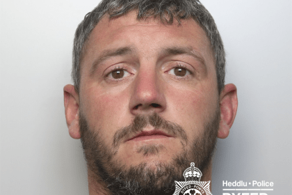 A police custody photograph of Leon Kidner, a man with short dark hair, a beard, and a large tattoo of roses on his neck.