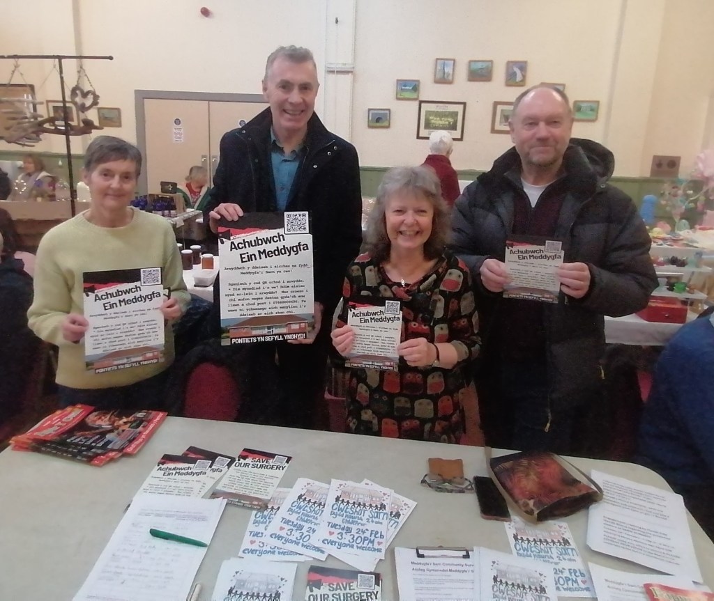 Group of campaigners holding Save Our Surgery leaflets at a community event in Pontyates.